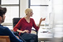 Man and woman in an office talking — Stock Photo
