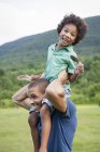 Father lifting son up onto shoulders — Stock Photo