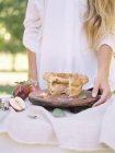 Mujer de pie en una mesa con tarta de manzana . - foto de stock