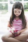 Girl playing with a smart phone. — Stock Photo