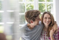 Couple embracing by a window. — Stock Photo