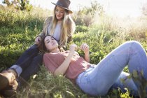 Две женщины лежат в траве . — стоковое фото