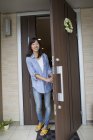 Femme debout à sa porte d'entrée . — Photo de stock