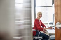 Женщина, сидящая за столом в офисе — стоковое фото