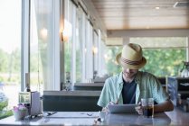 Homem em um restaurante usando um tablet digital — Fotografia de Stock