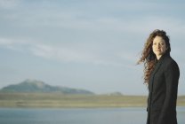 Mujer de pie en la orilla de un lago
. - foto de stock