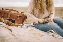 Donna seduta su una roccia con in mano un quaderno — Foto stock