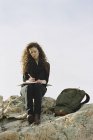 Frau sitzt auf einem Felsen und schreibt in ein Notizbuch — Stockfoto