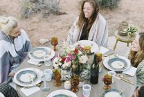 Женщин, наслаждающихся ужином на открытом воздухе в пустыне . — стоковое фото