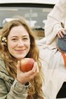 Женщина, протягивающая красное яблоко — стоковое фото