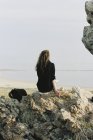 Жінка сидить на камені — стокове фото