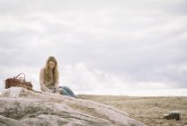 Femme assise sur un rocher — Photo de stock