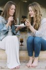 Frauen teilen Kuchen und ein Glas Wein. — Stockfoto