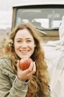 Frau hält roten Apfel in die Höhe — Stockfoto