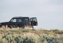 Femme debout par jeep — Photo de stock