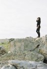 Donna in piedi su una roccia — Foto stock