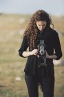 Женщина фотографируется со старой камерой . — стоковое фото