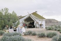 Amigos desfrutando de uma refeição ao ar livre na tenda — Fotografia de Stock