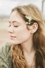 Donna con gli occhi chiusi con fiori nei capelli — Foto stock