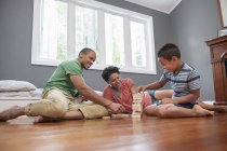 Família no chão a jogar um jogo — Fotografia de Stock