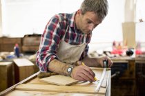 Restaurateur de meubles anciens mesurant le bois — Photo de stock