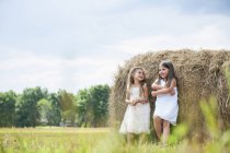 Girls by a large haybale — Stock Photo