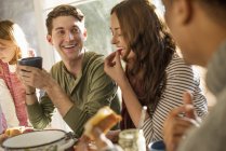 Menschen am Tisch, lächeln, essen, trinken — Stockfoto