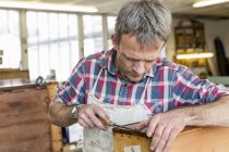 Человек в мастерской реставрации мебели — стоковое фото
