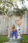 Dos hermanos jugando en el jardín - foto de stock