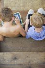 Brothers playing on digital tablets — Stock Photo