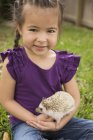 Menina segurando um pequeno ouriço — Fotografia de Stock
