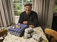 Bauer in einem Bauernhaus mit Tabletts mit frischen Eiern. — Stockfoto