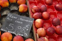Boxes of nectarines on a fruit stall — Stock Photo