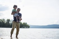 Father and son on a lake shore — Stock Photo