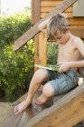 Мальчик играет на цифровом планшете — стоковое фото