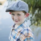 Young boy standing on a riverbank. — Stock Photo