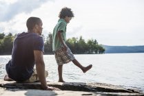 Padre e figlio su una riva del lago — Foto stock
