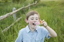 Boy blowing bubbles. — Stock Photo