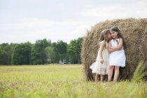 Meninas por um grande haybale — Fotografia de Stock
