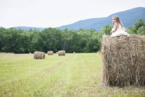 Menina jogando em grande haybale — Fotografia de Stock