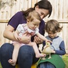 Donna e bambini con anatroccolo . — Foto stock