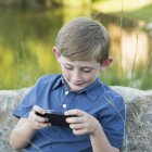 Boy using a handheld electronic game. — Stock Photo