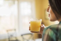 Frau hält Orangensaft in der Hand — Stockfoto
