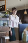 Офіціантка стоїть в кафе — стокове фото