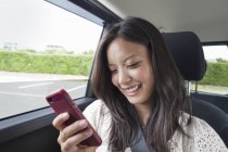 Frau benutzt Smartphone im Auto — Stockfoto