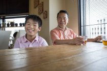 Man and boy sitting at dining table — Stock Photo