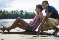Couple close together by a lake — Stock Photo