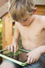 Junge spielt auf digitalem Tablet. — Stockfoto