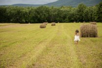 Girl by a large haybale — Stock Photo