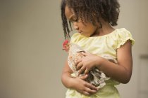Menina segurando uma galinha — Fotografia de Stock